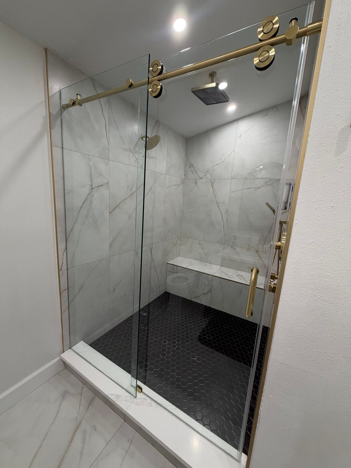 Premium shower glass hardware and brushed gold fittings on a frameless enclosure in Tampa